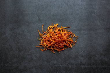 Kurumuş Cordyceps askeri mantarı koyu gri arka planda kasede. Cordyceps çiçeği