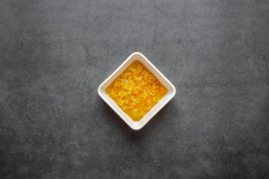 Siyah arka planda beyaz tabakta doğranmış zencefil kökü. en üstteki görünüm.