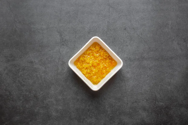 Siyah arka planda beyaz tabakta doğranmış zencefil kökü. en üstteki görünüm.