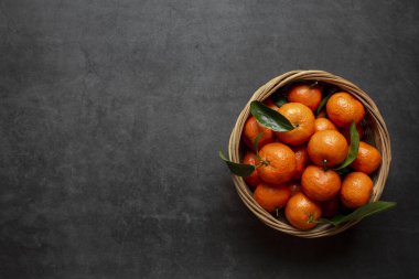 Koyu arkaplanda taze portakallar görünüyor. Sağlıklı yiyecekler. Düz yatıyordu. Kış zamanı meyveleri.