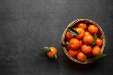 Koyu arkaplanda taze portakallar görünüyor. Sağlıklı yiyecekler. Düz yatıyordu. Kış zamanı meyveleri.