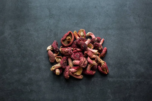Parlak kırmızı mantar, koyu gri arka planda kurutulmuş kırmızı mantarda iyi bir besin kaynağıdır..