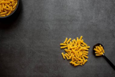 Koyu gri arkaplanda sarmal makarna.