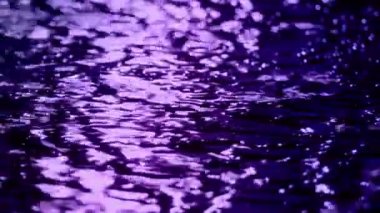 Şehir yolu yüzeyine yansıyan neon ışıklarla yağmur yağıyor.