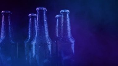 Parti ışıklarında bira şişeleri ve sigara damlıyor.