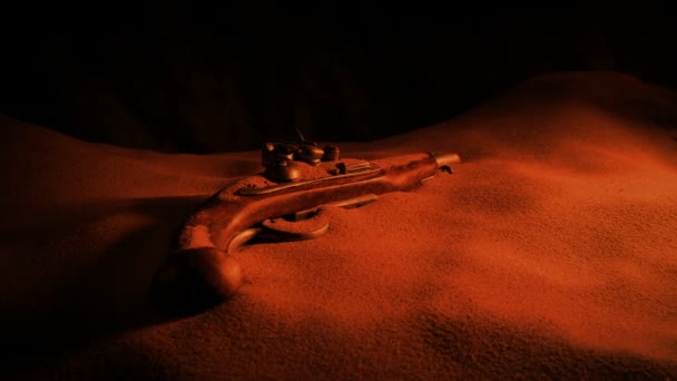 光に照らされた砂の中の海賊銃 — ストック動画