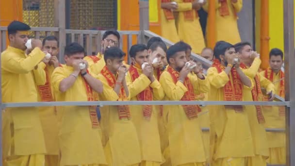 Santos indianos no maior festival de coleta Kumbh mela em Haridwar, Uttarakhand, Índia tocando shank, um instrumento de música indiana usando máscara de proteção Coronavirus, Appleprores422 4k Cinetone — Vídeo de Stock