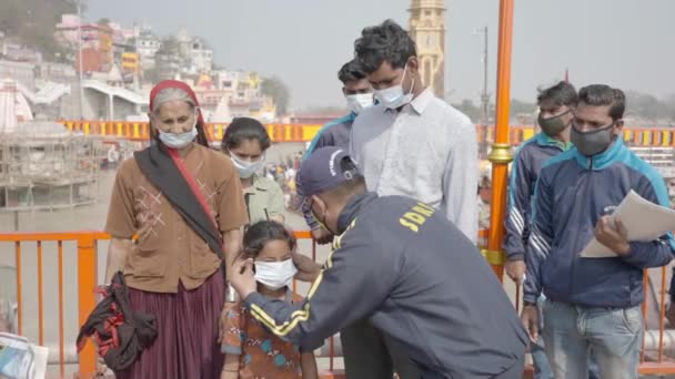 Αστυνομικοί που φορούν μάσκα προστασίας σε ένα παιδί για να παραμείνουν ασφαλείς από τον ιό Coronavirus κατά τη διάρκεια της Maha Kumbh 2021 — Αρχείο Βίντεο