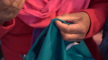 Himalayalar bölgesinin Hintli kadınlarının yakından çekilmiş fotoğrafları. Elleri kumaş dikişli. Yaşlı bir kadının elleri, iğne işi, nakış yapan bir kadın.