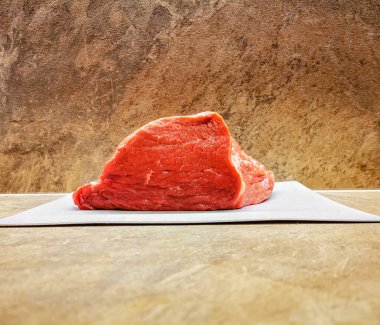 Kesme tahtasındaki taze kesilmiş kırmızı et parçası.