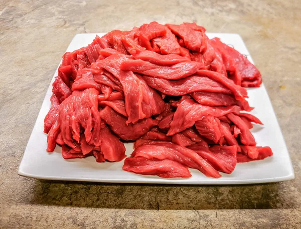 Freshly cut beef strips ready for marinade and making a beef jerky