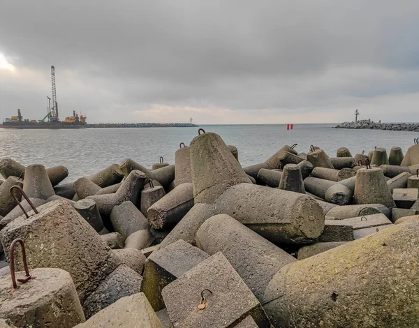 Photo of an artificial stone breakwater in the port at the sea gate — Stock Fotó