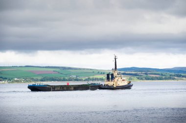 Römorkör denizde yüzen depolama platformu taşıyor.