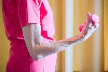 Pembe halterli yaşlı kadın halterci.