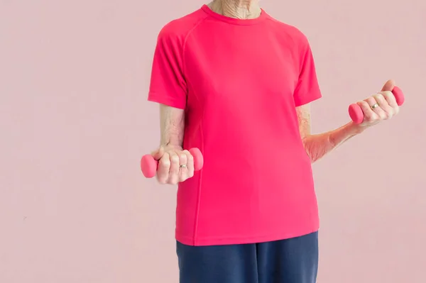 Senior elderly woman weightlifting with pink dumbbells — Stock Photo, Image