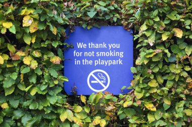 Çocuklarda sigara içmek yasak. Ebeveynler sigara içilmeyen çevre havası yaratmak için park tabelası koyuyorlar.
