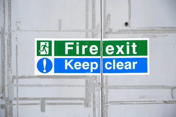 Fire exit keep clear sign on construction building site door — Stock Photo, Image