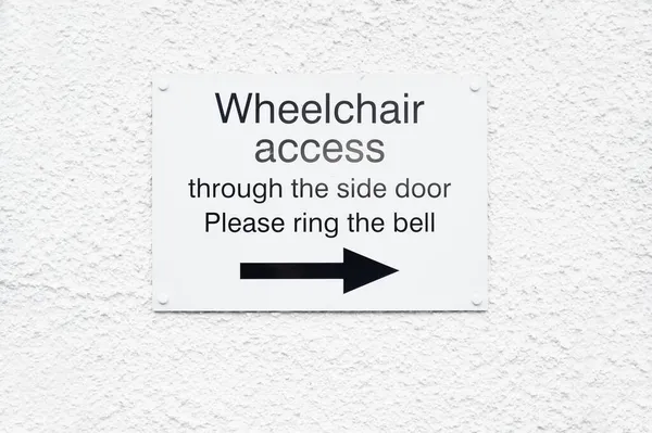 Wejście do rampy dla niepełnosprawnych użytkowników wózków inwalidzkich znak przy wejściu — Zdjęcie stockowe
