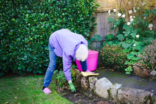 Senior äldre person aktiv livsstil i trädgården under sommaren — Stockfoto