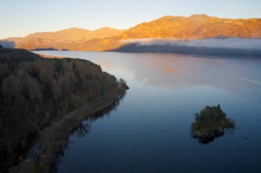 Tarbet yakınlarında güneş doğarken Lomond Gölü hava manzarası