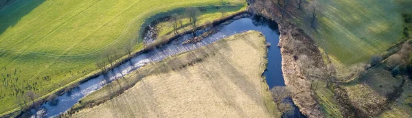 Вид з повітря на річку і порожнє зелене лугове поле — стокове фото