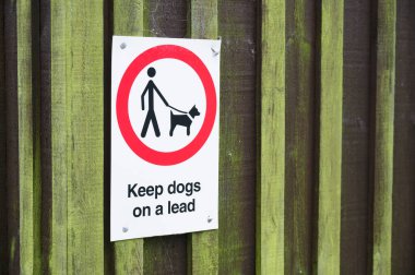 Köpekler halka açık park alanı tabelasında tasmalı ya da kurşunlu tutulmalıdır.