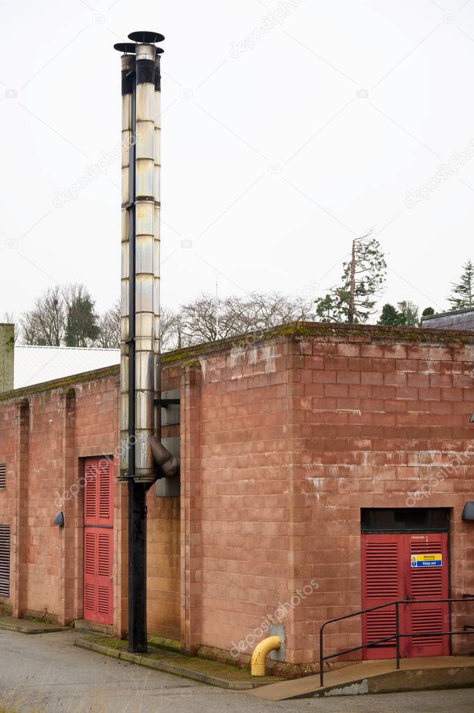 Flue chimney fixed to building exterior wall stainless steel from exhaust boiler plant room