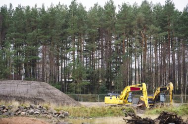 İnşaat şantiyesi kazısı sırasında inşaat alanı kazıcısı sarısı