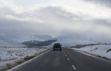 Buachaille Etive Mor dağı ve kış boyunca karla kaplı boş yol