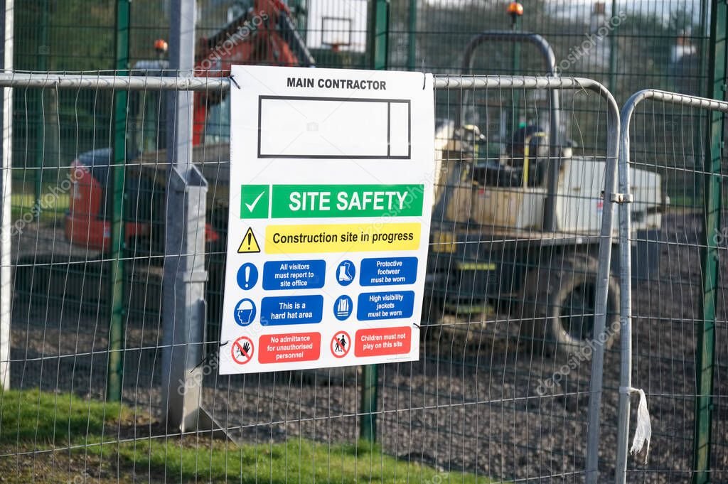 Construction site health and safety message rules sign board signage on fence boundary uk
