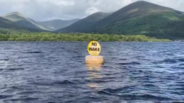 No wake water safety sign on buoy in Loch Lomond UK
