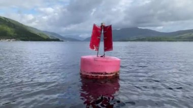 Red buoy in water to direct boats to safety in Loch Lomond UK