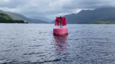 Red buoy in water to direct boats to safety in Loch Lomond UK