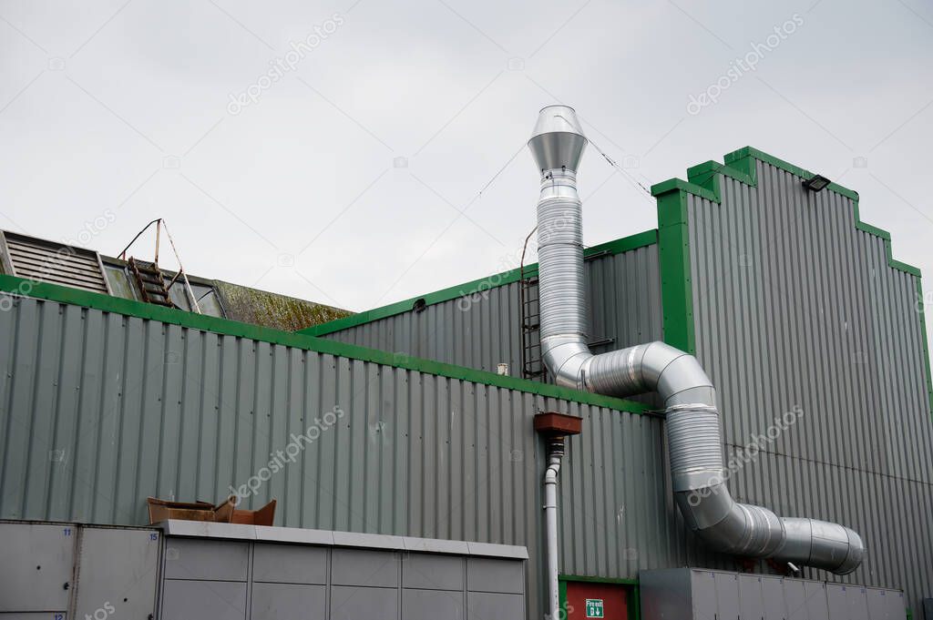 Flue chimney fixed to building exterior wall stainless steel from exhaust boiler plant room UK