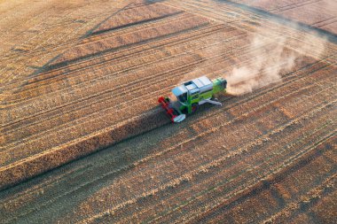 Combine harvester harvesting crops during sunset in Scotland UK