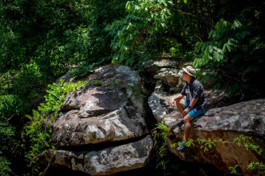 A man siting on top of mountain and enjoying view. image have grain and noise, blur and soft focus.