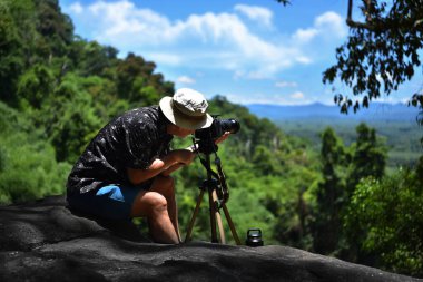 Yaşlı adam dağlarda yürüyüş yapıyor ve Tayland 'da fotoğraf çekiyor. görüntü tahıl ve gürültü, bulanık ve yumuşak odak var.