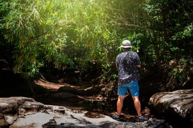 Yaşlı adam dağlarda yürüyüş yapıyor ve Tayland 'da fotoğraf çekiyor.