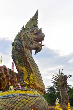Stucco, Wat Tham Nam Tad Suwan Kanlaya Dham Tapınağı, Thap Kung, Nong Saeng Bölgesi, Udon Thani Bölgesi, Tayland 'da bir naga ve ejderha yakın çekimi olarak resmedildi. Görüntü tahıl, gürültü, bulanık ve yumuşak odaklı.