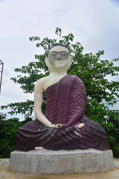 The big statue buddha of Luang Pu Thuat sitting on cemen plinth at Wat Tham Nam Tad Suwan Kanlaya Dham temple, Thap Kung, Nong Saeng District, Udon Thani Province, Thailand.