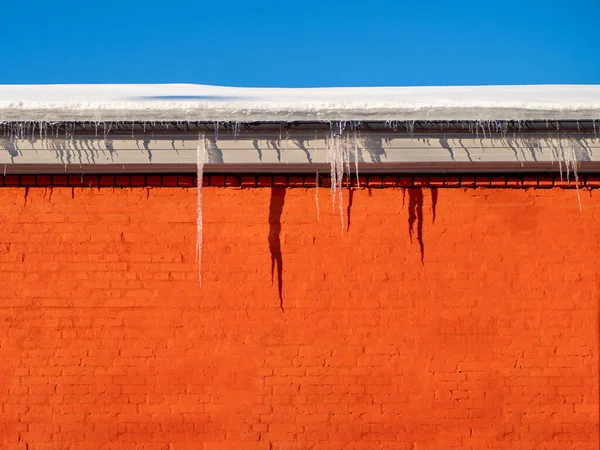 Large winter icicles hanging from the house roof — 스톡 사진