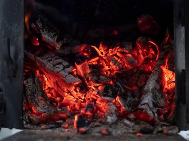 Details of charcoal in the furnace. Burning firewood in the grill, bright coals and flames. Burning campfire embers.