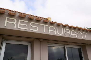 Şehir caddesindeki dükkanın ön cephesinde restoran metin tabelası