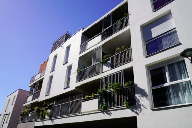 Mavi gökyüzüne karşı birçok penceresi olan ön bina.