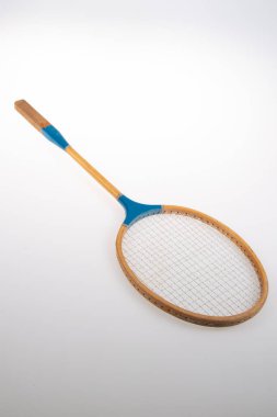 Eski badminton raketleri ahşap ve gri arka planda mavi plastik.