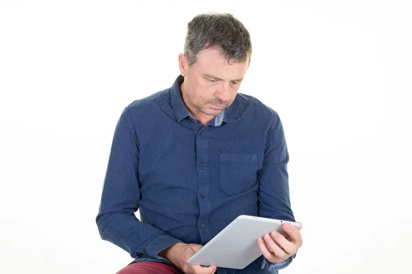 Pohledný Muž Hledá Při Čtení Svého Digitálního Dotykového Tabletu — Stock fotografie
