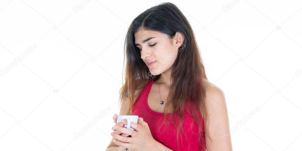 pretty pensive woman gazes dreamily at her hot cup of coffee