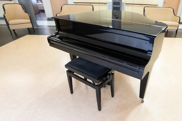 Black shiny grand piano black on wooden stage