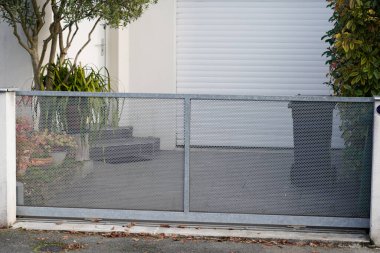 Kapısı delinmiş modern gri tasarım kapısı. Banliyödeki evin önünde alüminyum gümüş kapı var.