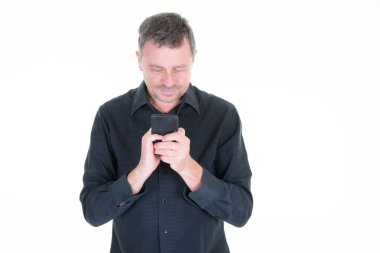 Siyah tişörtlü akıllı telefondan mesaj atan bir adam ekrandaki telefon uygulamasında mutlu bir şekilde gülümsüyor.